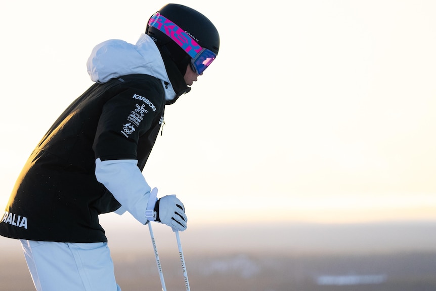 Jakara Anthony stands leaning forward on her ski poles