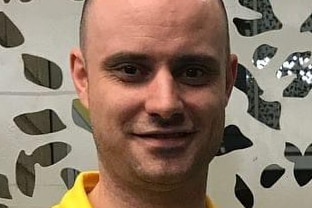 A headshot of a gymnastics coach Jeb Silsbury. He is smiling at the camera