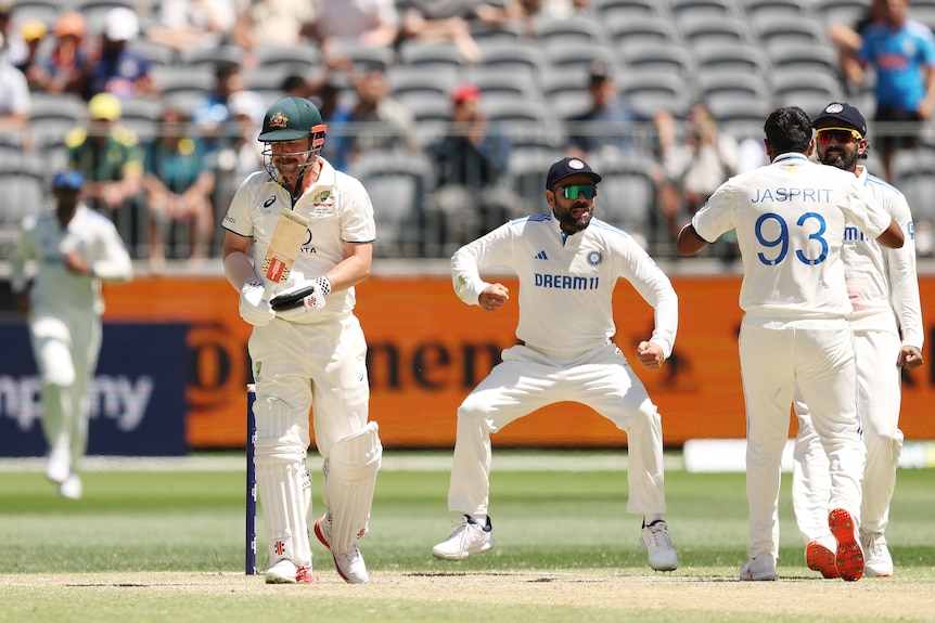 Travis Head walks off as Indian players celebrate
