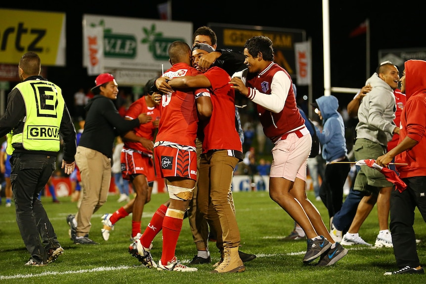 Fans celebrate a win in a rugby league match