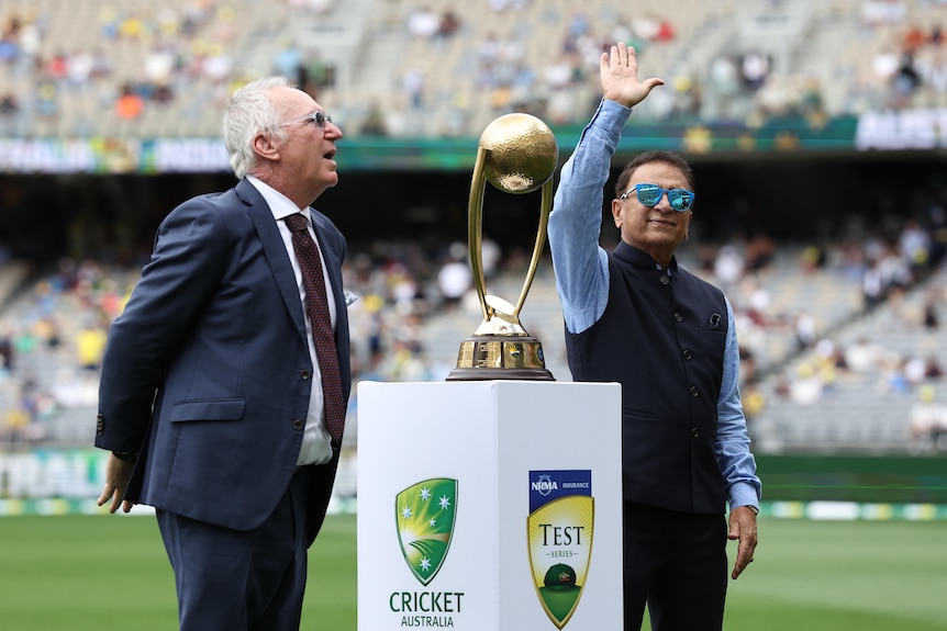 Sunil Gavaskar salutes the fans while standing next to Allan Border