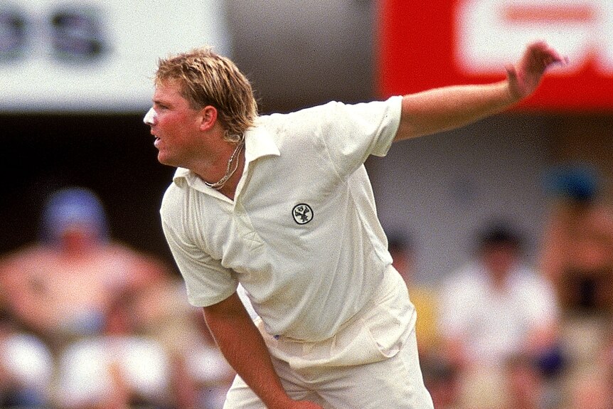 Shane Warne completes his bowling action in his first Test against India at the SCG.