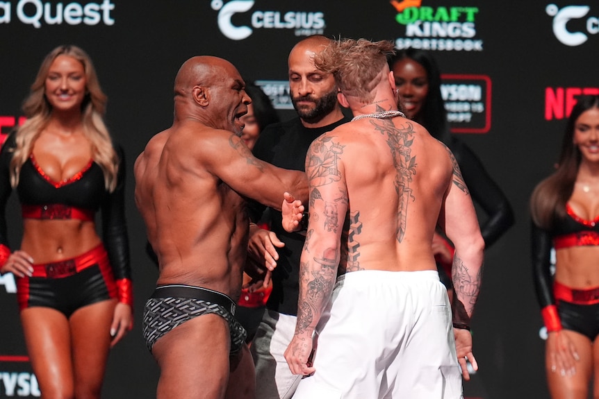 Jake Paul's (right) head is twisted away from the camera after he was slapped by Mike Tyson (left).
