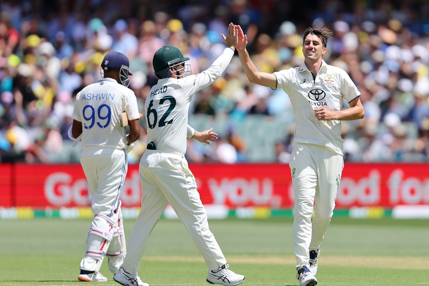 Pat Cummins high-fives Travis Head as he runs through in celebration