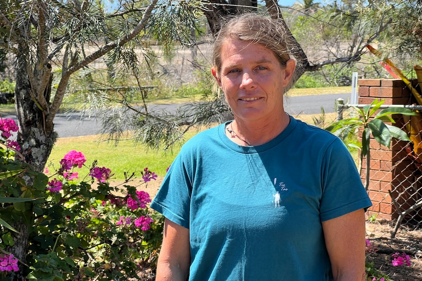 A woman standing in front of a front yard garden