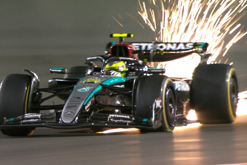 Lewis Hamilton driving his F1 Mercedes with sparks flying from a tyre puncture