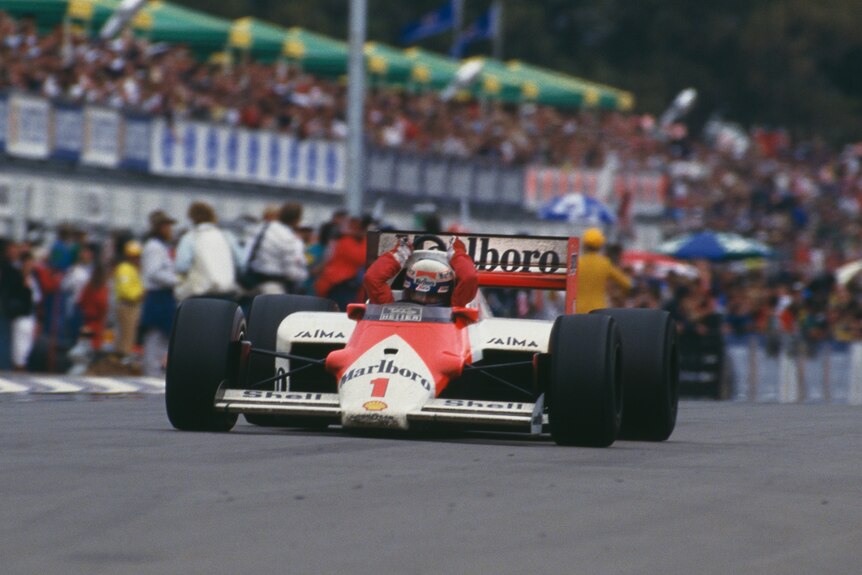 Alain Prost wins the 1986 F1 Australian Grand Prix, driving past the finish line, raising his hands in triumph