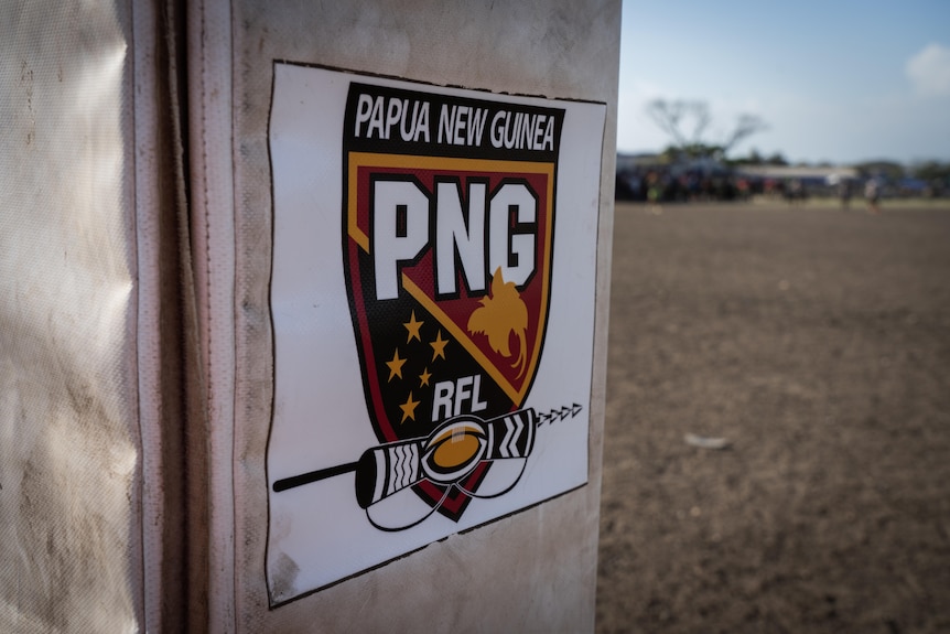 A close up of a sign with Papua New Guinea's rugby league crest in red, yellow and black.