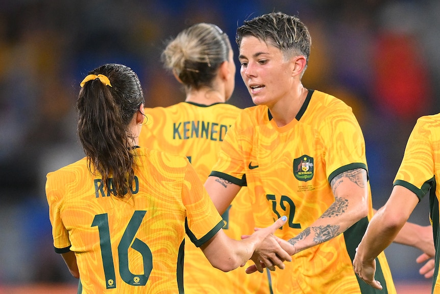 Michelle Heyman high-fives Hayley Raso while playing for the Matildas.
