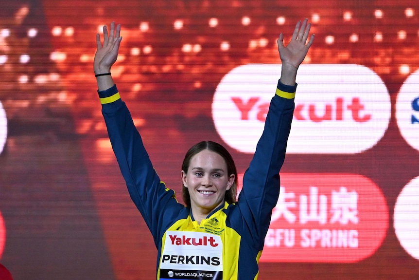 Alex Perkins holds up her arms