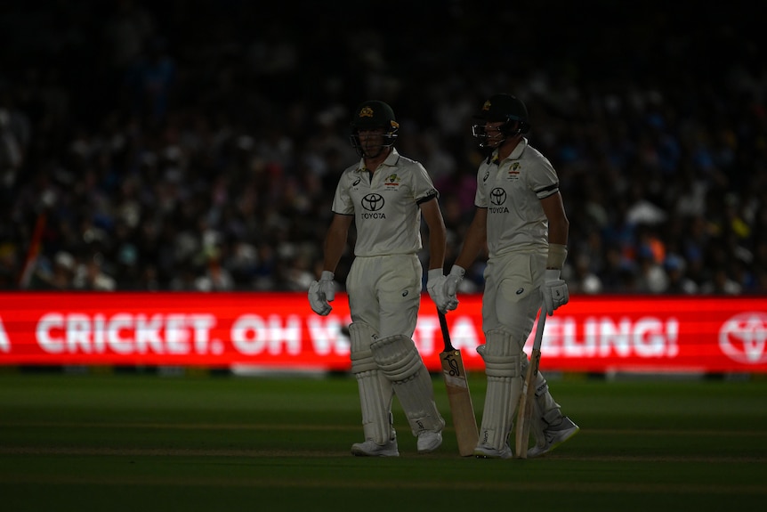 Nathan McSweeney and Marnus Labuschagne stand in the dark