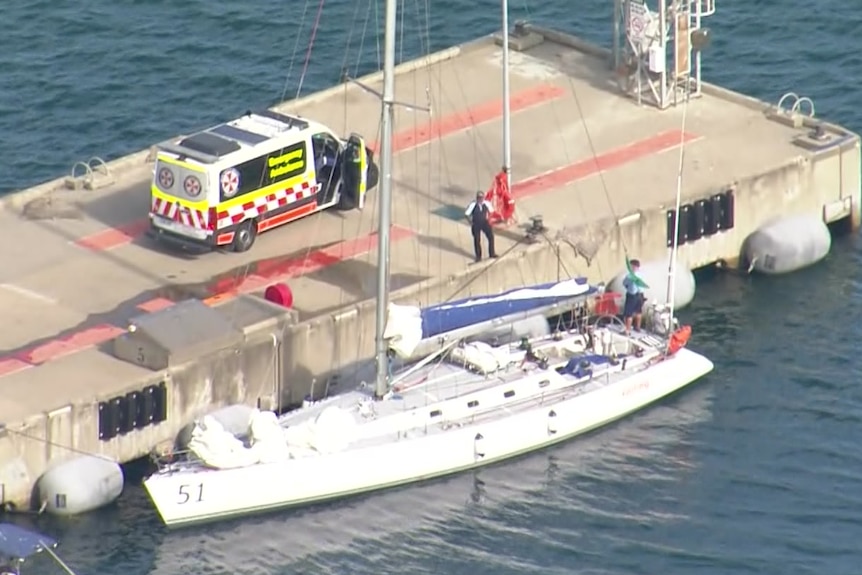 Ambulance attends a boat next to a jetty.