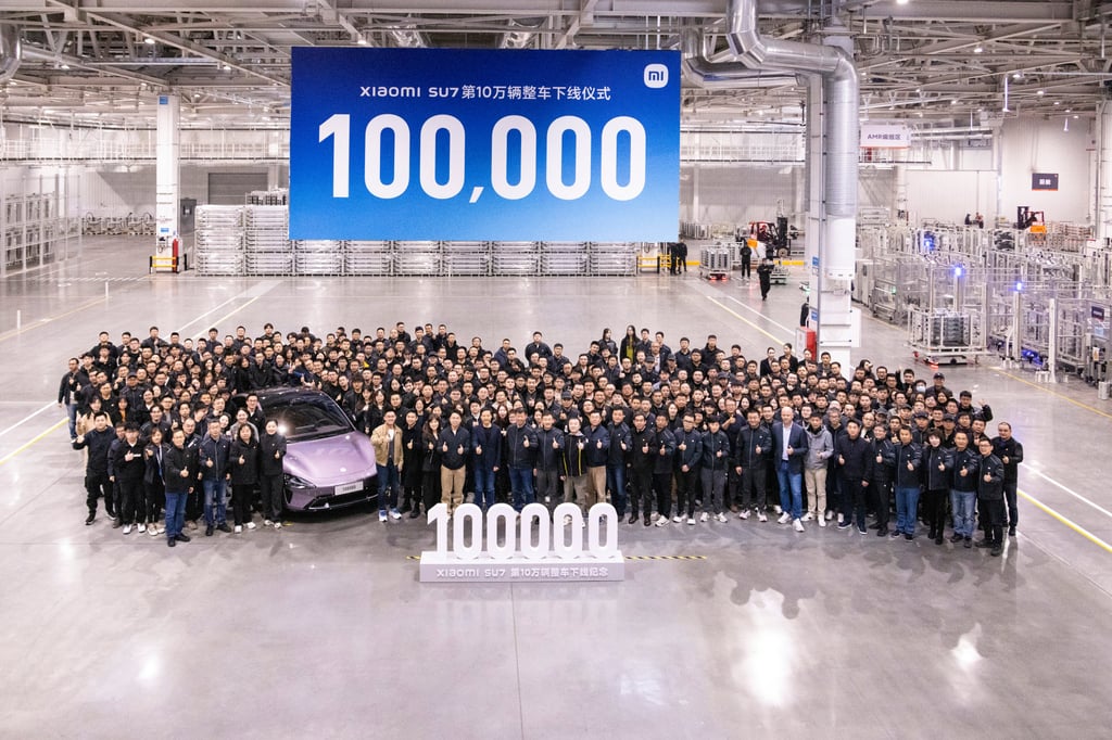 Xiaomi CEO Lei Jun and staff with the 100,000th SU7 rolled out from the assembly line. Photo: X/leijun