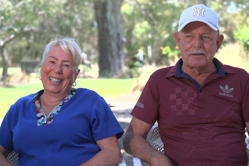 Ella and David Kairl sitting alongside each other on white plastic chairs 