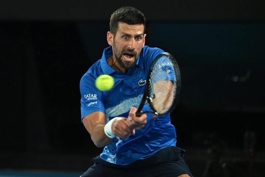 Novak Djokovic hits a double-hande backhand shot, grunting, during a charity tennis match