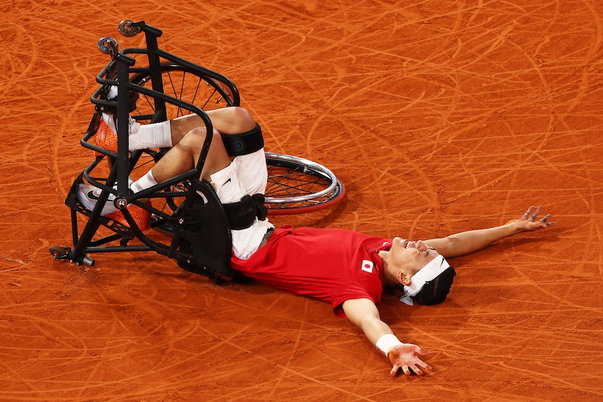 Oda lying on his back on a clay court.