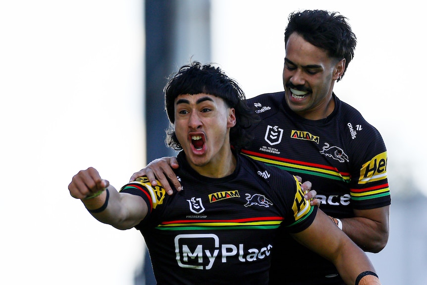 A man celebrates after scoring a try in a rugby league match 