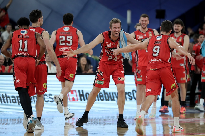 Basketballers celebrate during an NBL game.