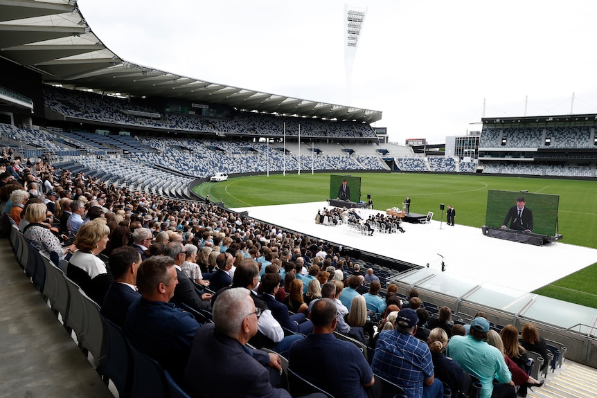 A crowd sits at Troy Selwood's memorial service at Kardinia Park.