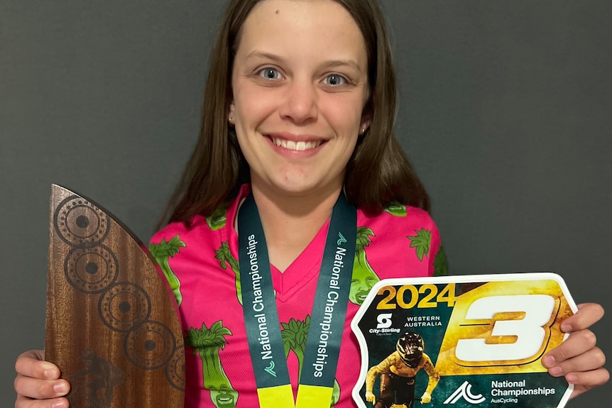 A young BMX racer smiling with a medal after BMX success