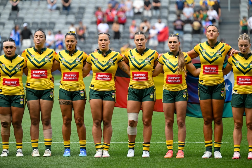 Jillaroos players stand for the national anthem ahead of a Test against New Zealand.