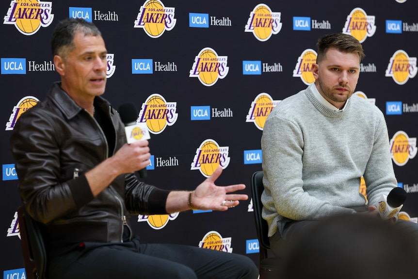 Rob Pelinka speaks while Luka Doncic looks on