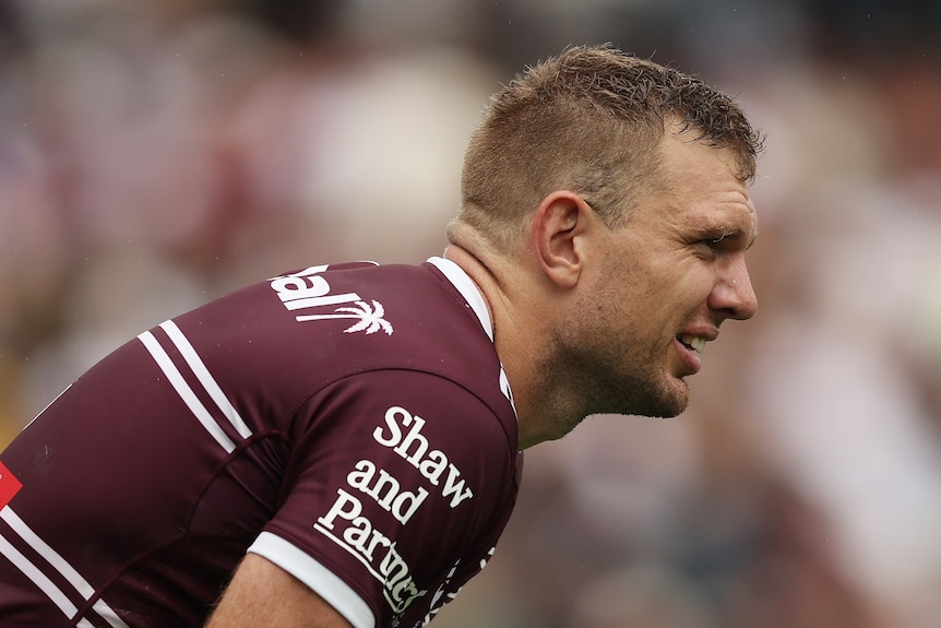 Tom Trbojevic of the Sea Eagles looks on with pain on his face, bending over