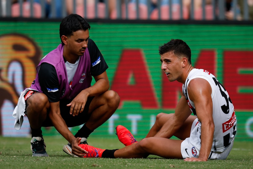 Nick Daicos is tended to by a Collingwood physio