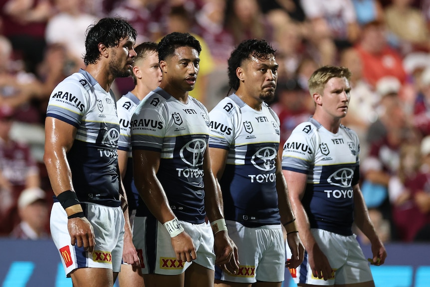 Cowboys players stand in a line