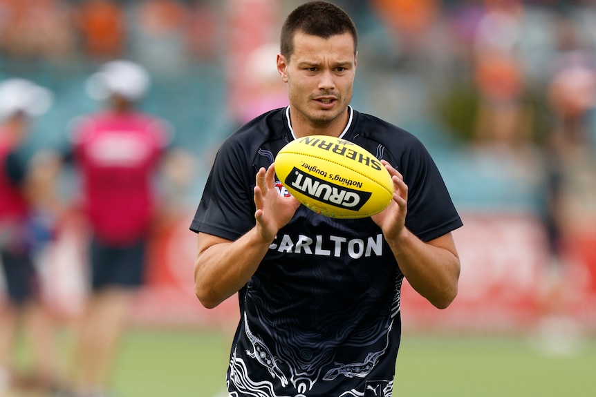Jack Silvagni catches a ball as he warms up for an AFL preseason match.
