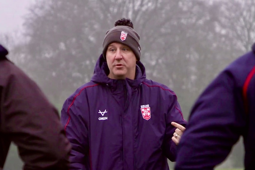 A rugby league coach speaking to his players.