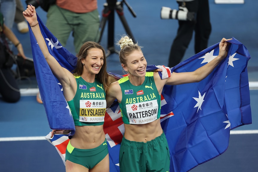 Nicola Olyslagers and Eleanor Patterson pose with Australian flags at the world indoor athletics championships high jump final.