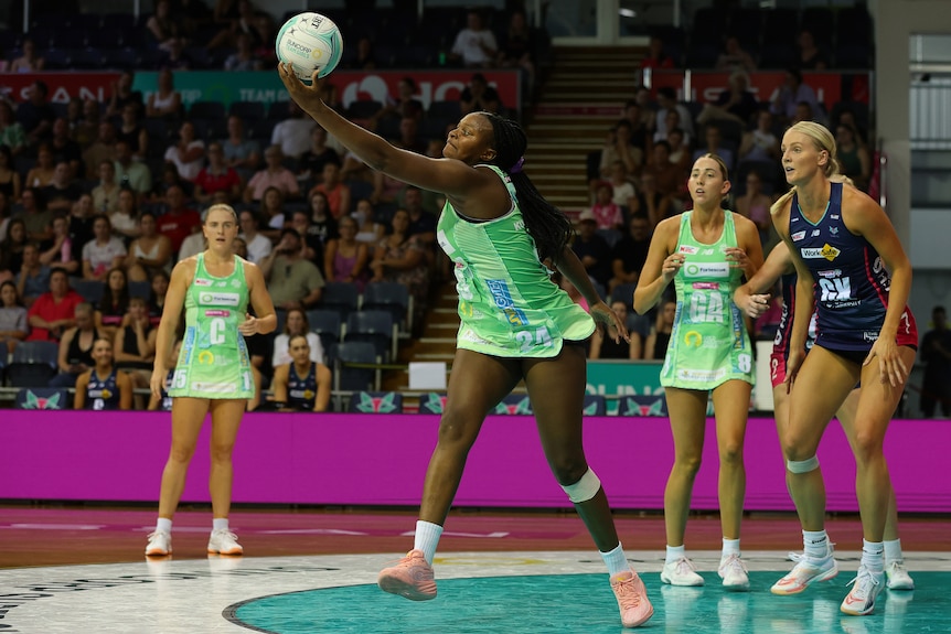 A player reaches out to catch a ball wearing a green dress