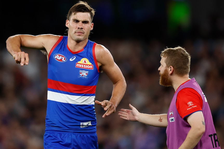 Sam Darcy with a trainer after injuring his knee against St Kilda.