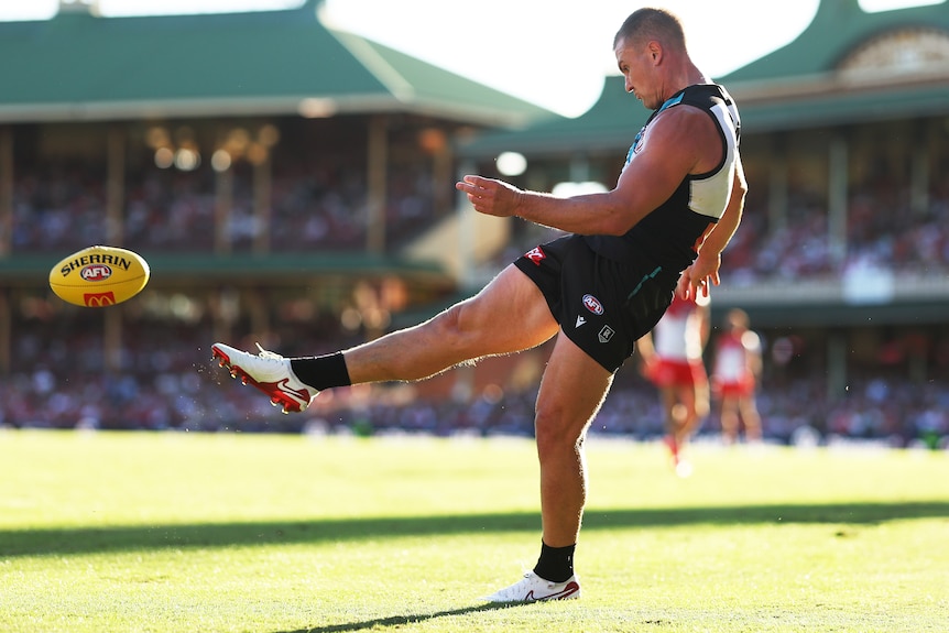 Ollie wines kicks the ball for the Power against the Swans.