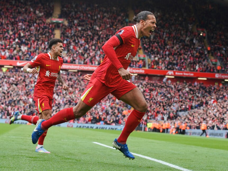 Liverpool's Virgil van Dijk roars in celebration as he sprints away after scoring a goal in the Premier League.