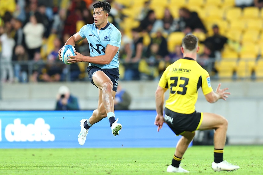 Joseph-Aukuso Suaalii holds the ball in mid-air for the Waratahs against the Hurricanes.