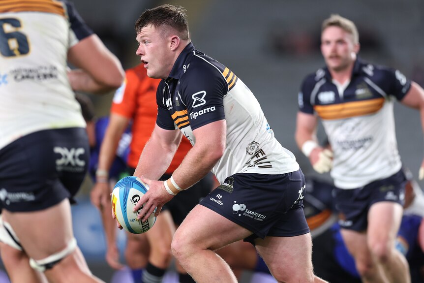 Billy Pollard runs the ball for the Brumbies against the Blues.