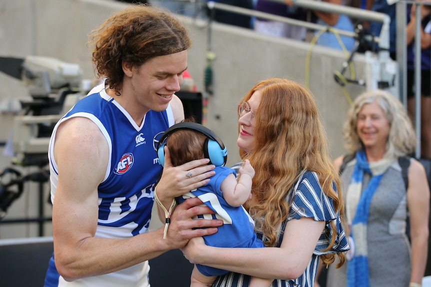 Hester and Ben Brown with their young child who is wearing headphones