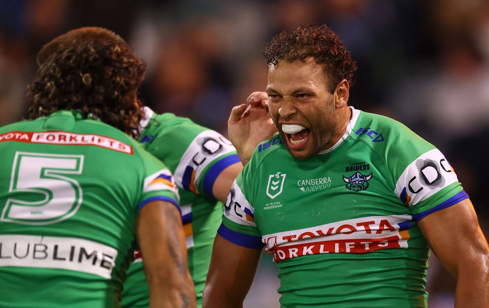 Sebastian Kris shouts while looking at Xavier Savage as they celebrate a Canberra Raiders try.
