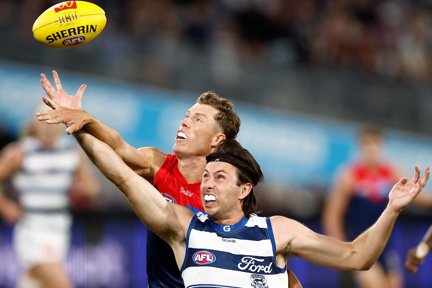 Jake Melksham and Jack Henry compete for the football in the air