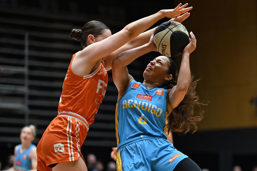 Veronica Burton holds the ball for the Bendigo Spirit while under defensive pressure against the Townsville Fire.