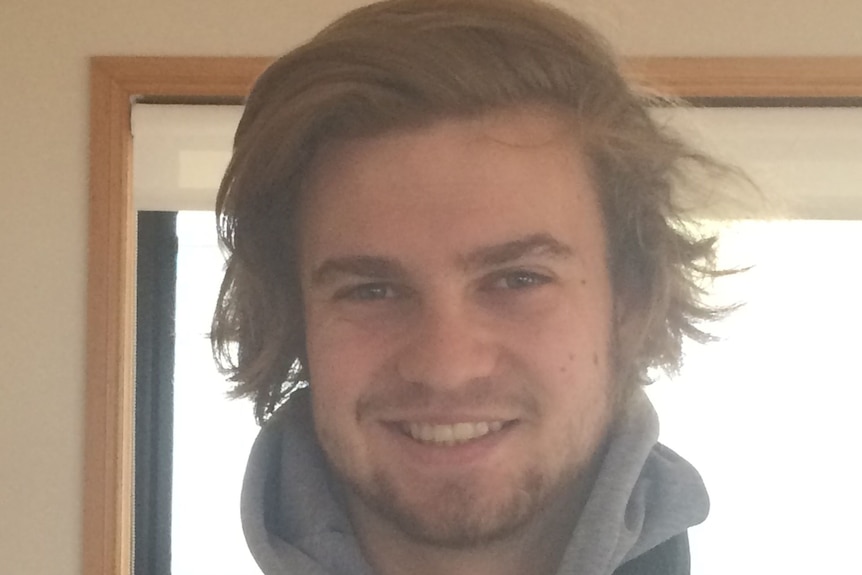 Head and shoulder image of a young man smiling.