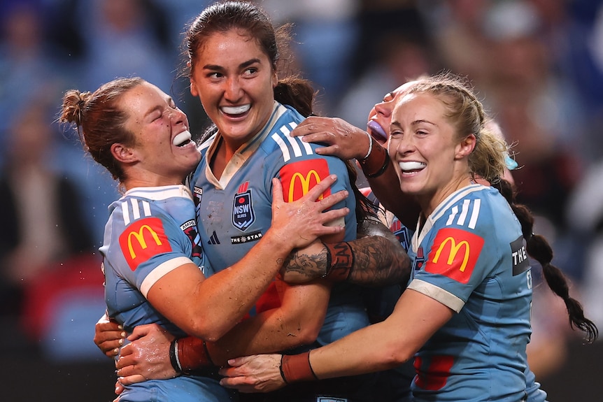 Olivia Kernick and Blues teammates celebrate a try.