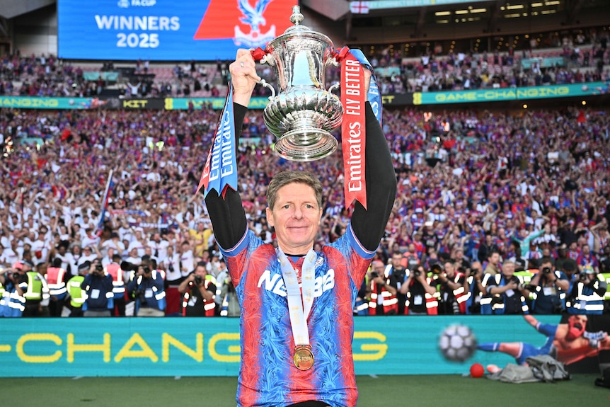Oliver Glasner holds up the FA Cup trophy.