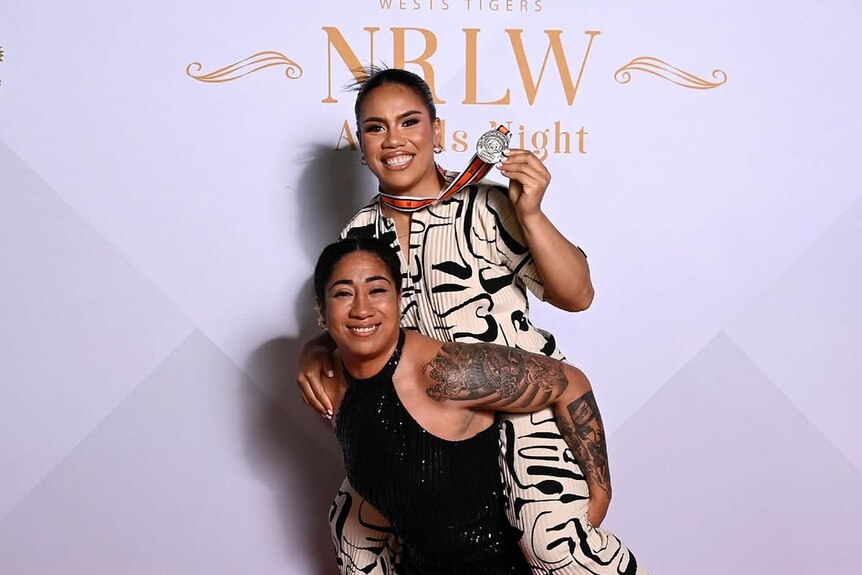 Sarah Togatuki rides on her sister Jean's back at the Wests Tigers' NRLW Awards Night in 2023.