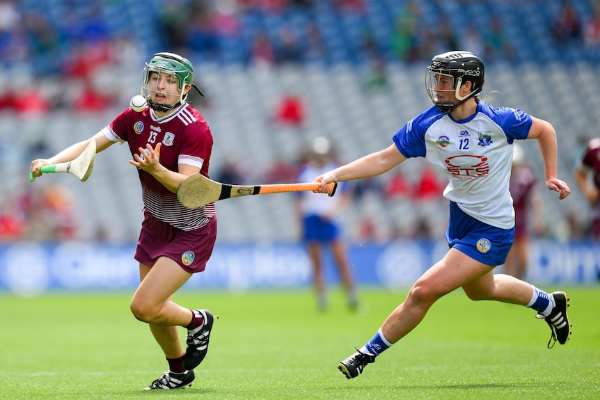 Galway and Waterford players compete for the ball in a camogie match.