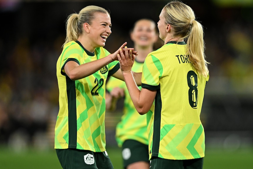 Charlotte Grant of Australia (left) celebrates after Kaitlyn Torpey scores a goal.