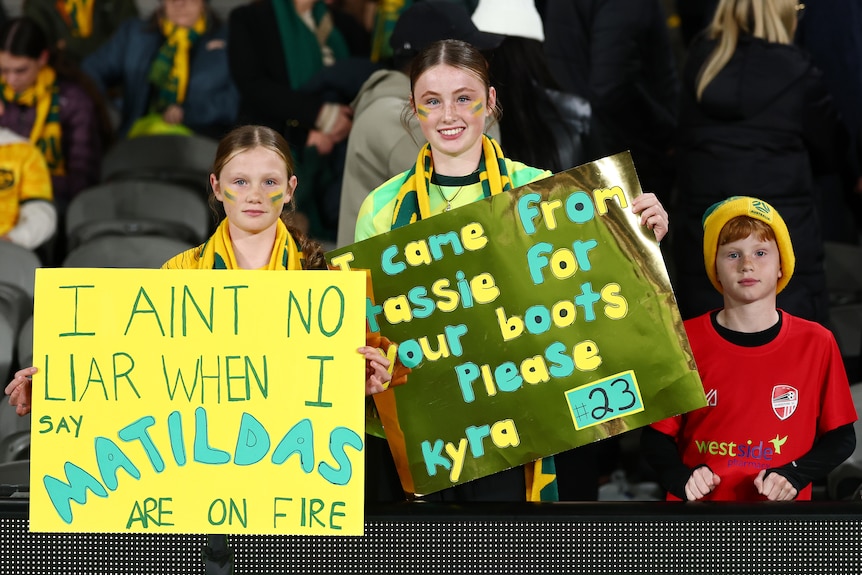 Matildas fans hold up placards at Docklands.