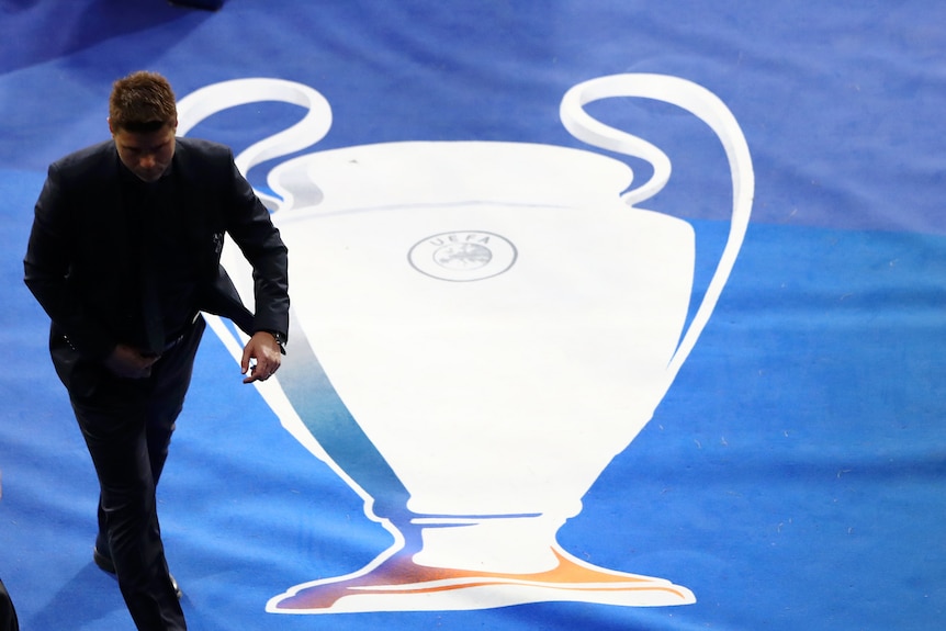 Mauricio Pochettino walks down a tunner with the Champions League trophy